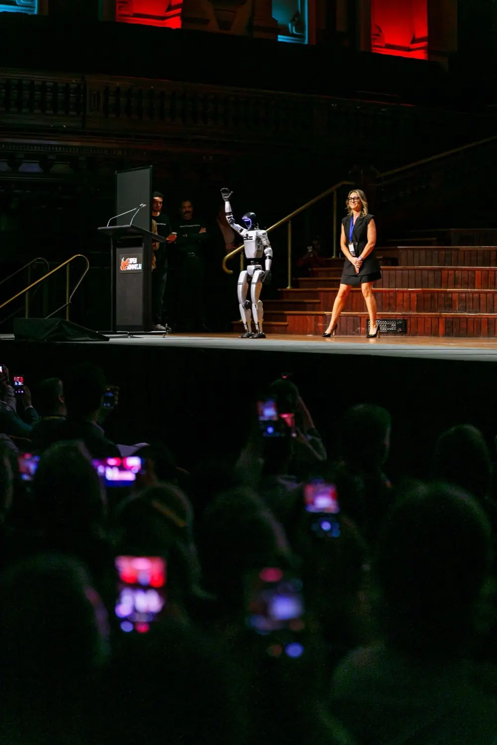 A presenter with a humanoid robot on the Open Summit stage.