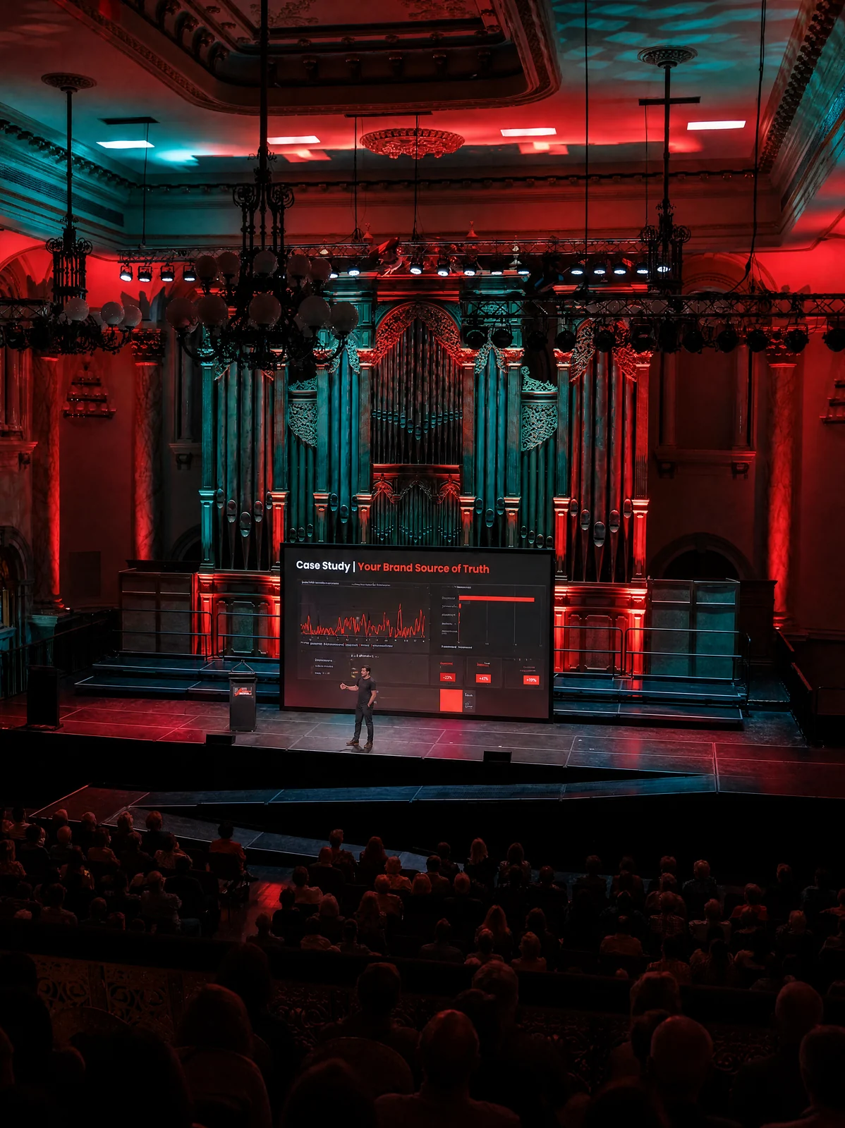The stage and auditorium at Adelaide Town Hall under red and teal lights